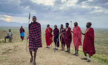A group of Maasai men in colorful traditional garments in the scenic landscapes of Arusha, Tanzania.
