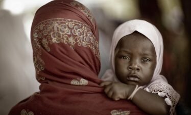An intimate portrait of a mother with her child in traditional dress, Zanzibar.
