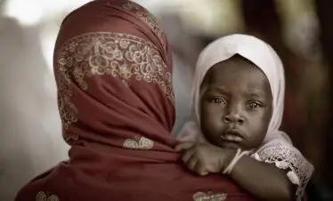 An intimate portrait of a mother with her child in traditional dress, Zanzibar.