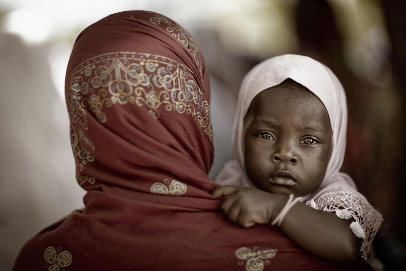 An intimate portrait of a mother with her child in traditional dress, Zanzibar.