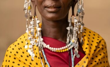 Maasai woman adorned in traditional attire and jewelry in Tanzania.