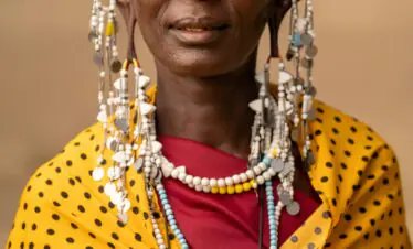 Maasai woman adorned in traditional attire and jewelry in Tanzania.